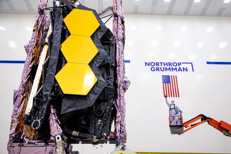 レドンドビーチにあるノースロップ・グラマン社のSpace Park施設のクリーンルームで、リフトに乗った技術者が完成状態のジェームズ・ウェッブ宇宙望遠鏡の点検・検査を実施 写真提供:ノースロップ・グラマン社 Northrop Grumman Enables James Webb Space Telescopes Coldest Instrument to Reach Operational Temperature_1 - Japan